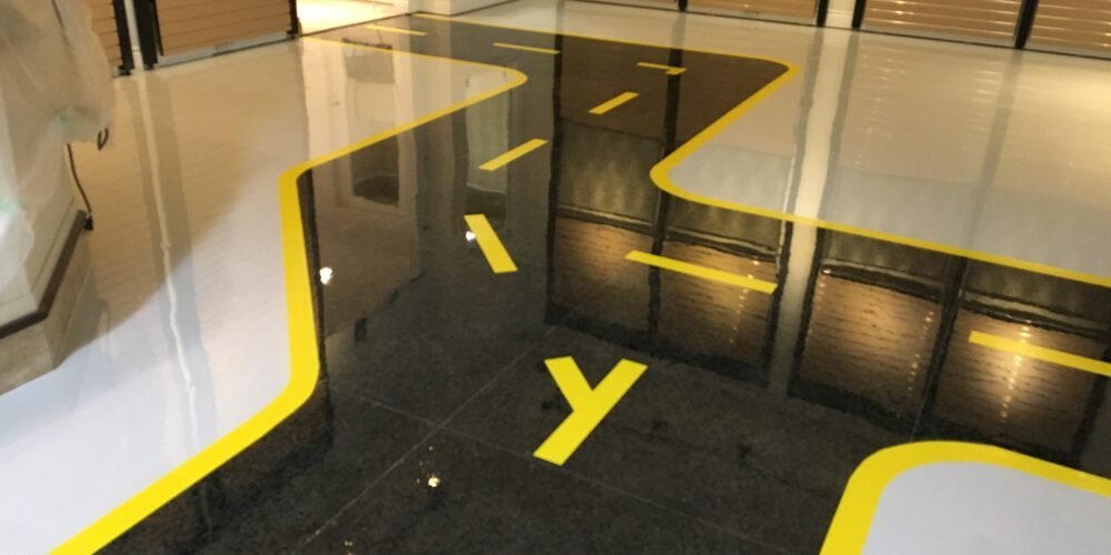 black and yellow road design epoxy floor for a motorcycle showroom near Ottawa, Ontario